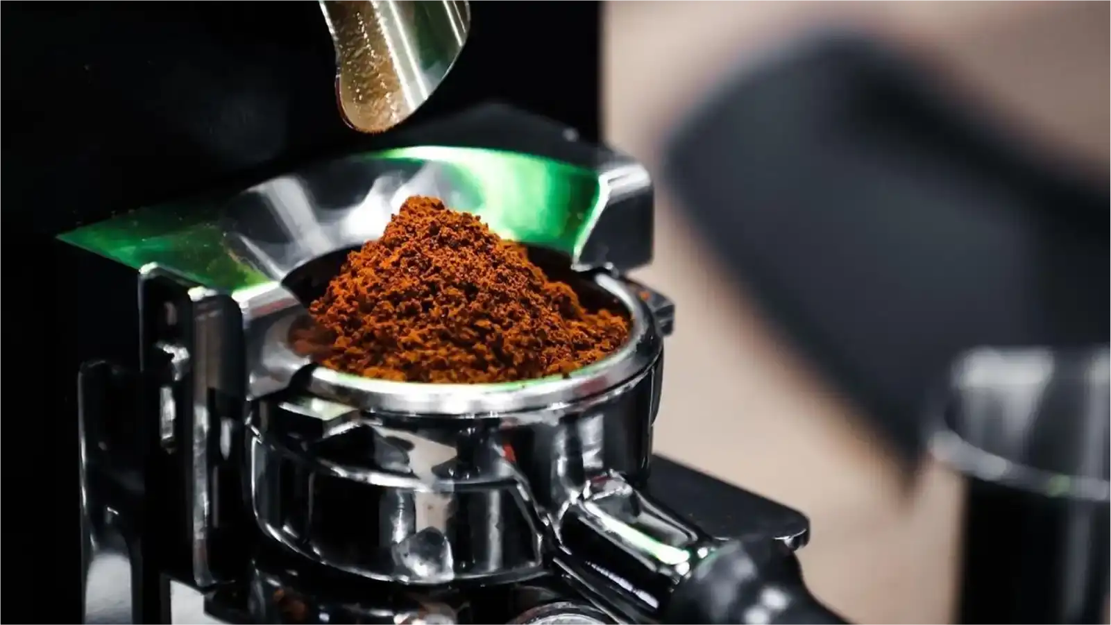 Professional barista using a commercial grinder with precision dosing