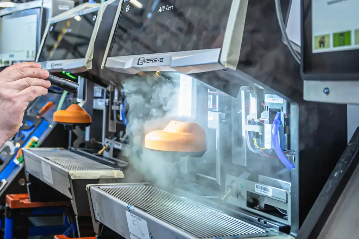 Technician performing maintenance on commercial espresso machine